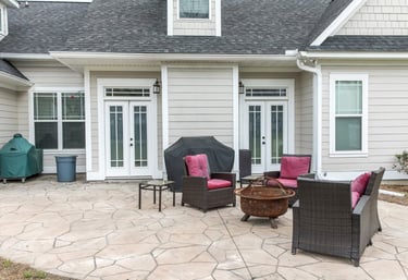 a stamped concrete patio with a patio furniture set up