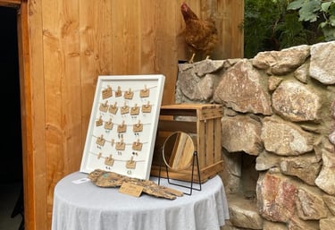 Schmuckausstellung auf Holztisch mit Spiegel und Huhn daneben