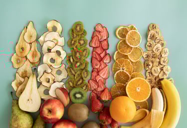 Sobre fondo verde, frutas frescas y rodajas deshidratadas: pera, manzana, kiwi, frutilla, naranja.