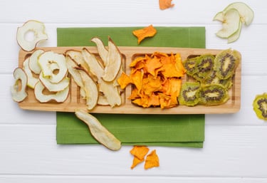 Tabla de picada con manzana, pera, mango y kiwi deshidratados en rodajas.