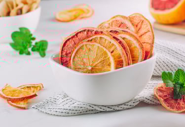 Bowl de cerámica con rodajas deshidratadas de pomelo, naranja y limón.