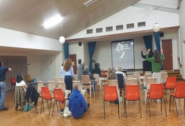 a group of people standing in a room with chairs and a projector - worship encounter night