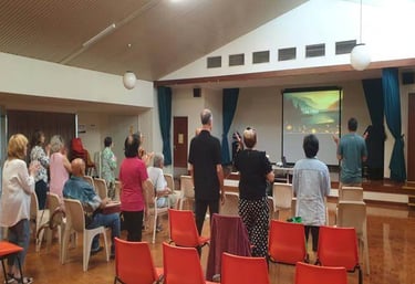 a group of people standing in front of a screen to worship