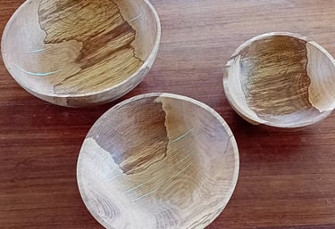 3 turned wooden bowls with thin turquoise kintsugi-style highlights, viewed from above