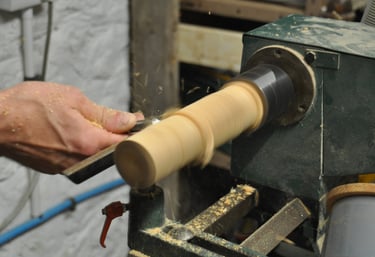 Close-up of a column of wood being turned on a lathe