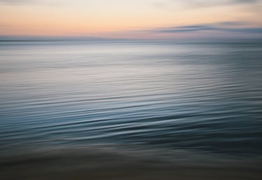 Soft waves shot in ICM on a calm ocean at sunset in Mauritius with gentle pastel hues