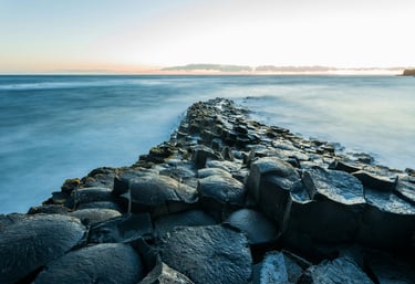 a long exposure of a rocky beach with a view of the ocean