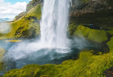 a waterfall in iceland with people standing around it