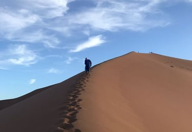 Visitor climbing Erg Zahar dune, Morocco, known as the ‘dune of whispers’