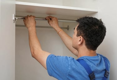 Technician assembling a large wooden wardrobe in a bright Singapore apartment.