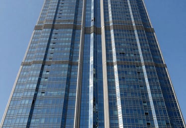 A stunning architectural photograph of a modern glass skyscraper in Dubai reflecting a bright blue sky, representing corporate strength and global digital reach.