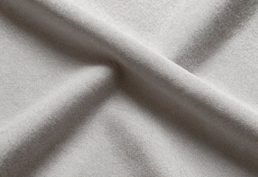 Modern automotive textile fabric in dark tones, showing weave pattern and texture.