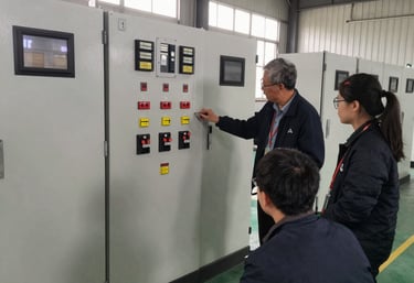 Engineers collaborating on a complex PLC panel in a modern industrial training lab.
