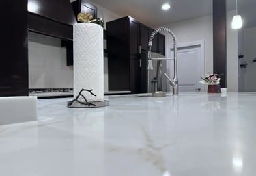 Close up of polished quartz countertop surface showing brown veining detail.