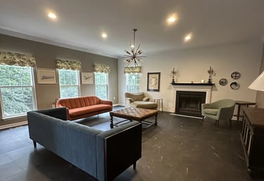 a living room with a couch and a fireplace and vinyl tile.