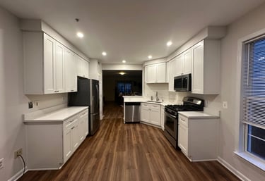 A full kitchen transformation with new white shaker cabinets, quartz countertops, and warm LVP floor