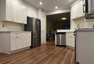 Spacious kitchen remodel with white cabinets, pro stainless steel appliances, & counter space.