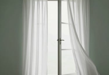 Minimalist shot of an open window with white curtains blowing slightly in the breeze. Soft, airy, and professional. Sage green and white palette.