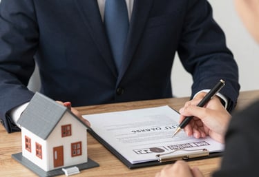 A friendly mortgage broker discussing options with a young couple in a cozy office.