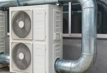 Technician installing large industrial air conditioning unit inside a factory.