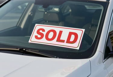 A close-up of a &amp;amp;amp;#x27;SOLD&amp;amp;amp;#x27; sign placed behind the windshield of a clean, polished luxury vehicle in a North American &amp;amp;amp;#x2F; US dealership lot.