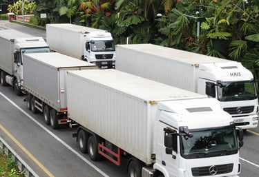 A cargo ship unloading containers at a busy port under a clear sky.