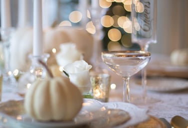 a table setting with a white table cloth and candles