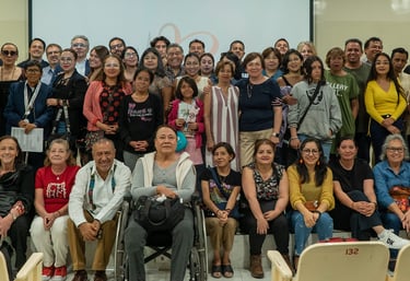 Un grupo diverso de personas posando para una foto de reunión comunitaria en una sala de conferencia