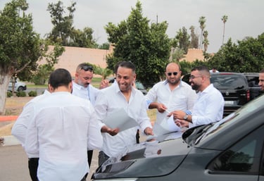a group of men standing around a car