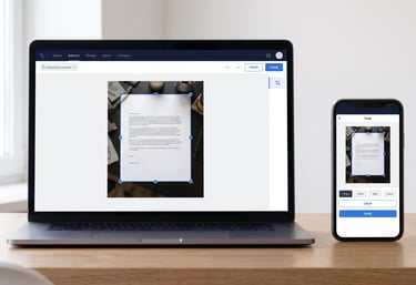 Laptop and smartphone displaying a document cropping software interface on a wooden desk.