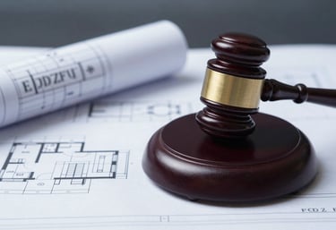 A legal gavel and a set of blueprints, representing compliance and rigorous standards. The lighting is professional and moody, using #1A202C and #EDF2F7.