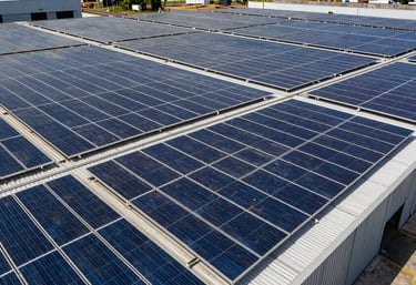 Wide shot of a large industrial warehouse in Brazil with an extensive array of solar panels covering the entire roof surface.