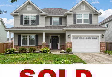 Two-story gray suburban house with red brick accents and a large red SOLD sign overlay.