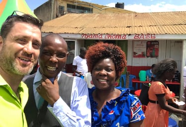 Pastors Shea and Jackson taking a selfie outside a Nyama Choma barbecue restaurant in Kisumu