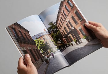 Hands holding a high-quality architectural magazine. Clean and inspiring environment.