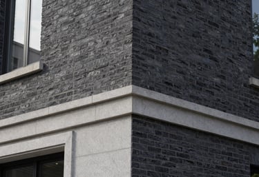 Architectural detail of high-quality Dark Charcoal brickwork and Light Grey stone finishes on a modern North American / US building exterior.