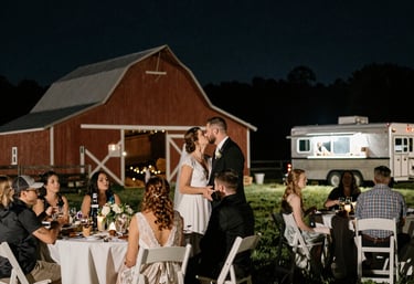 A colorful food truck serving a variety of plated dishes at an outdoor event.