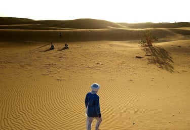 a person standing in a desert with a hat on