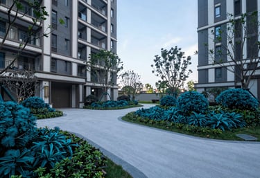 A wide photograph of a perfectly lit courtyard in a multifamily development, showing clear sightlines and manicured landscaping in deep teal pine colors.