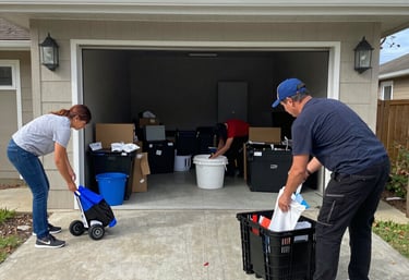 Professional cleaners organizing supplies and equipment in a garage for Breaking Grime Bros services.