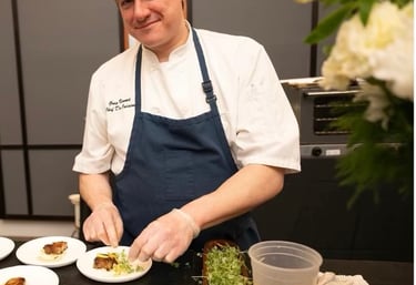 Chef Greg serving pork belly and green curry puree and pickled carrots