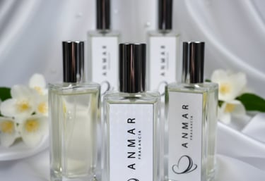 Anmar Fragancia perfume bottles on white silk fabric with jasmine flowers and pearls.