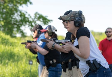 People outdoors training in the defensive use of firearms