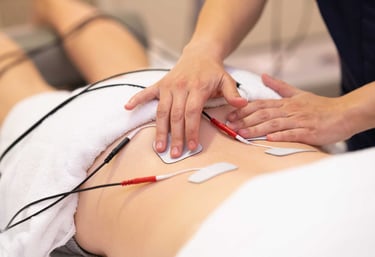 Profissional da saúde posicionando eletrodos do aparelho TENS nas costas do paciente