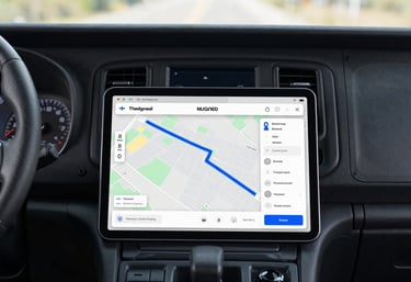 A top-down view of a tablet showing a navigation map with a clear route highlighted in blue, placed next to a truck dashboard, symbolizing strategic route planning.
