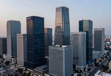 An aerial view of the modern Gurugram skyline at dusk, showcasing steel and glass buildings in deep navy and light gray-blue tones, representing the firm's operational base.