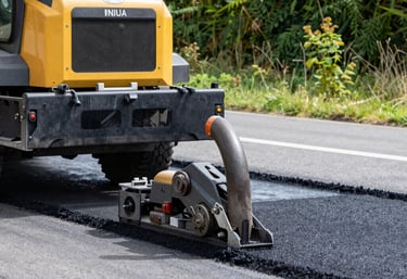 A civil engineer reviewing blueprints on a construction site with heavy machinery in the background.