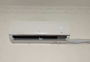 White Midea wall-mounted inverter air conditioner unit displaying 17 degrees on a white wall.