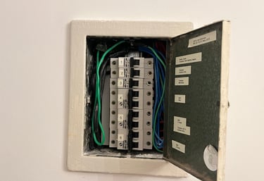 Open electrical breaker panel showing labeled circuit breakers and organized wiring for home safety.