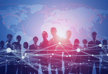 Diverse business team silhouettes standing before a digital world map with global network connections.